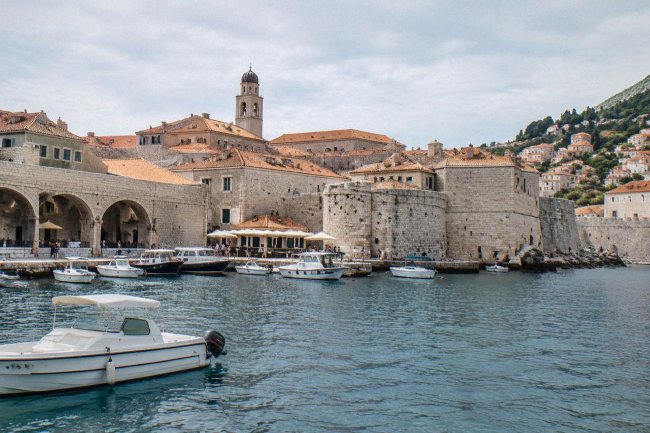 Dubrovnik's walled old town and terracotta roofs above the harbour, seen from the water