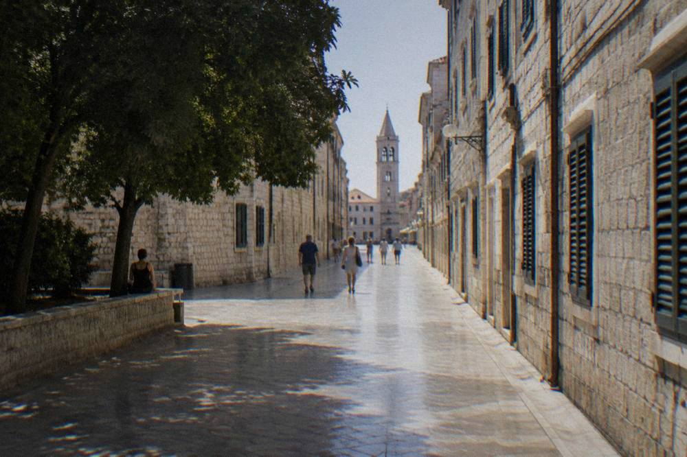 The polished limestone pedestrian street of Kalelarga in Zadar with a few distant walkers