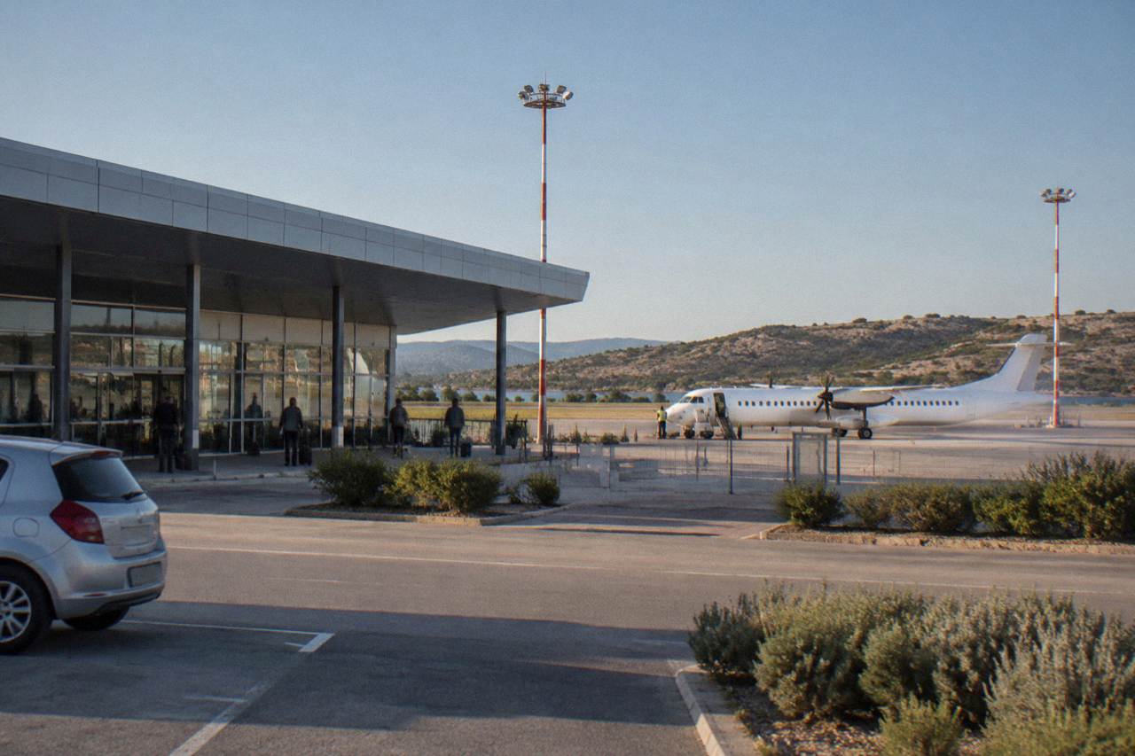 Zadar airport terminal exterior under a clear sky with a small plane on the apron
