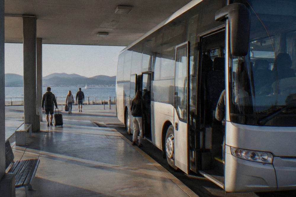 A coach parked at a covered bus bay with an open door at Zadar bus station