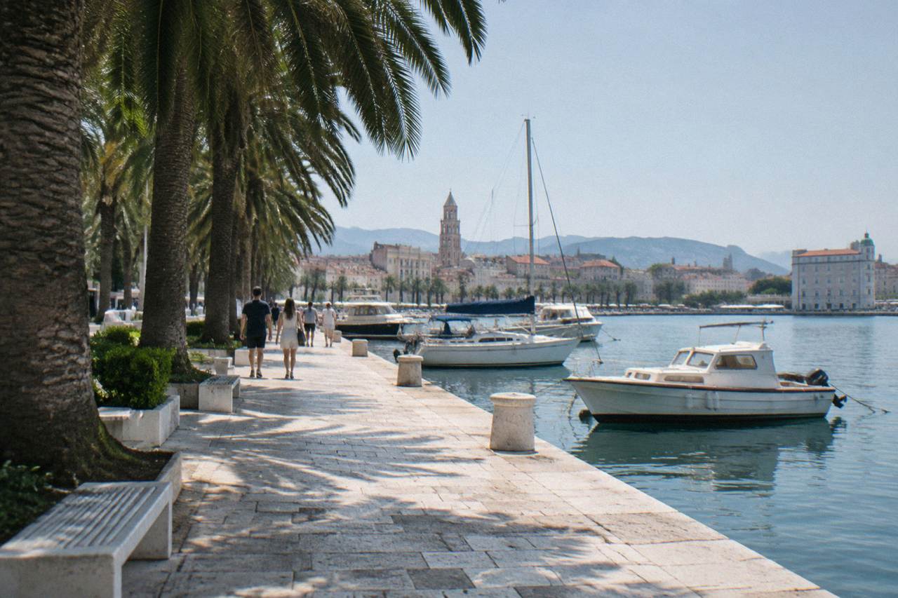 The palm-lined Riva promenade in Split with the harbour and moored boats in morning light