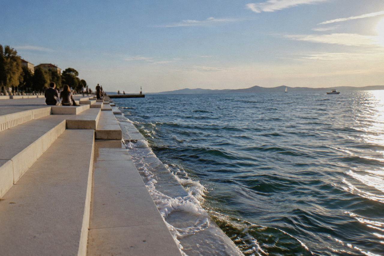 Wide white limestone steps of the Sea Organ descending into the Adriatic Sea in late afternoon
