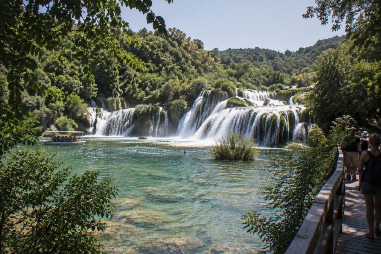 Broad cascades spilling over mossy travertine steps into green pools at Skradinski Buk
