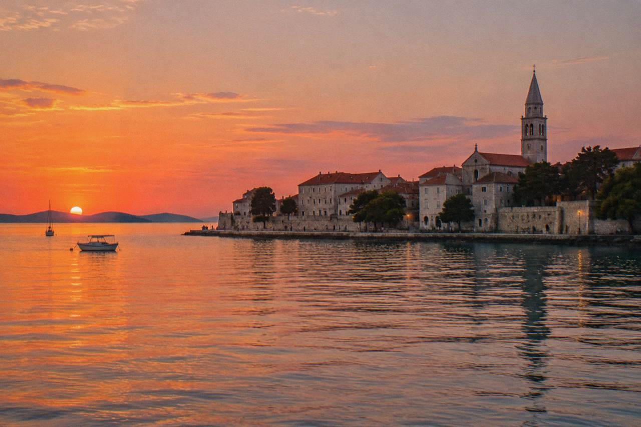 Zadar Old Town peninsula from the water at sunset with terracotta roofs and a bell tower