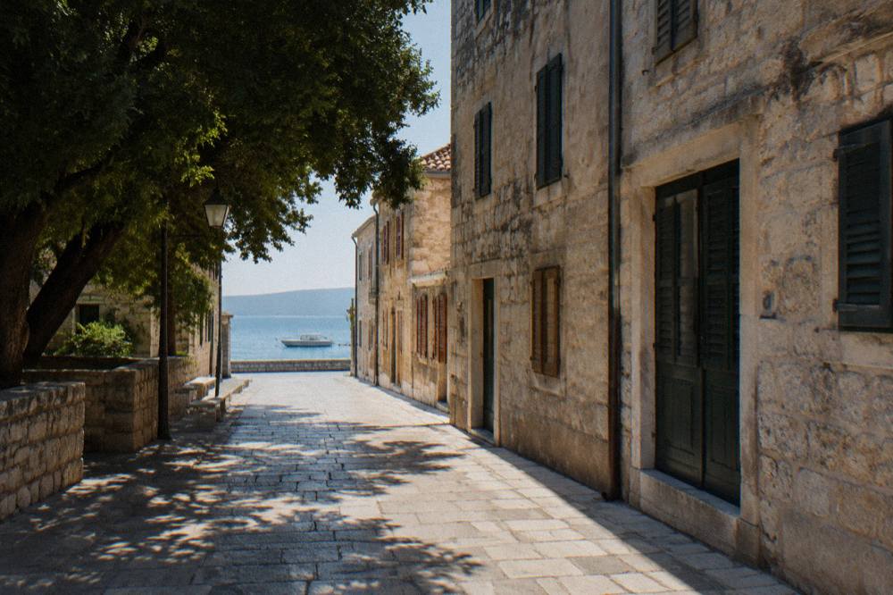 Quiet stone lane in Zadar Old Town in soft light with empty paving and shuttered windows