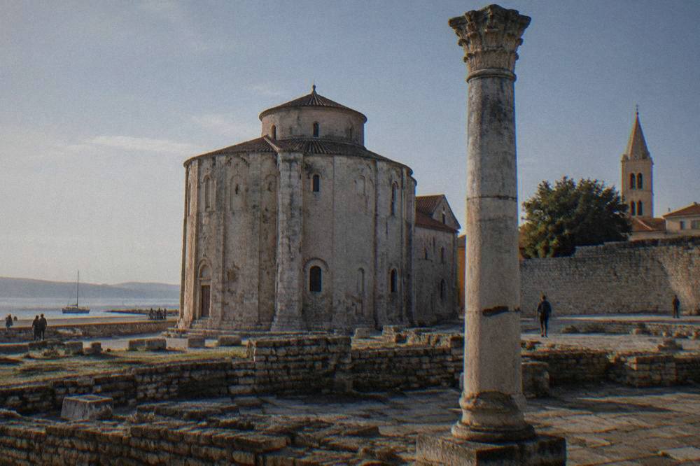 The round Church of St Donatus beside the Roman Forum with the city wall beyond
