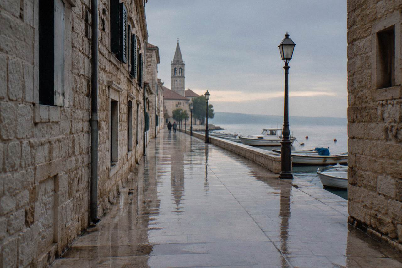 Wet limestone paving in a Zadar Old Town lane with reflections after rain