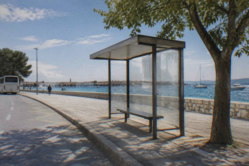 Empty bus stop shelter beside a quiet road near Zadar's station in morning light