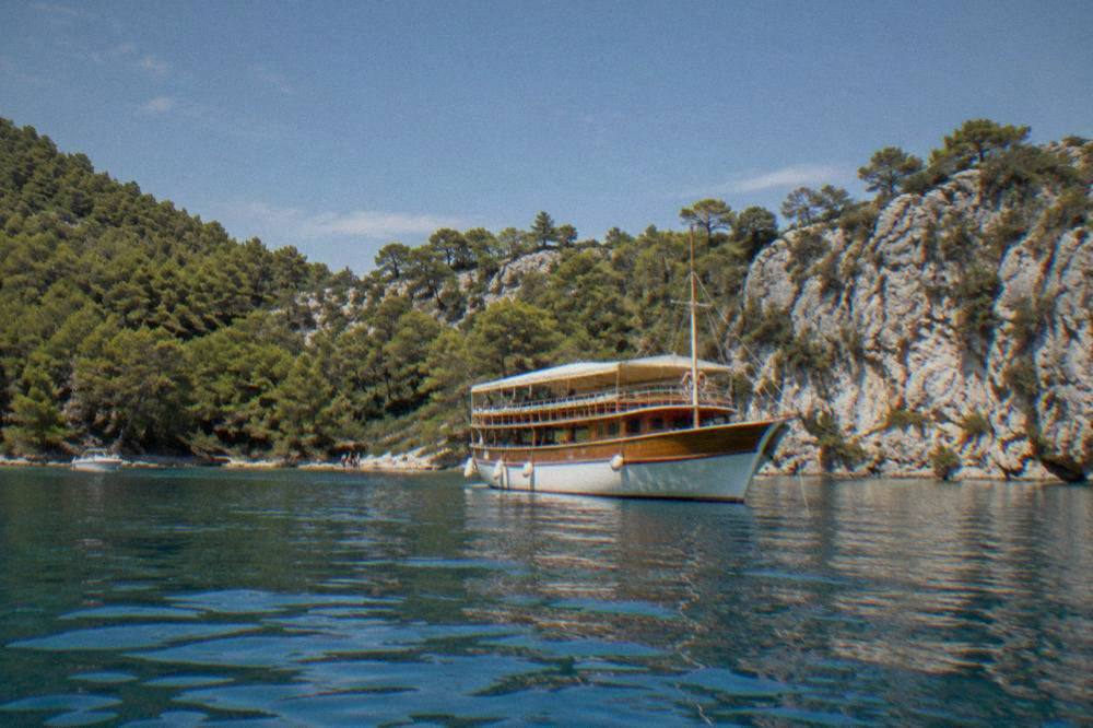 Wooden boat anchored in a sheltered pine-fringed bay in Telašćica Nature Park