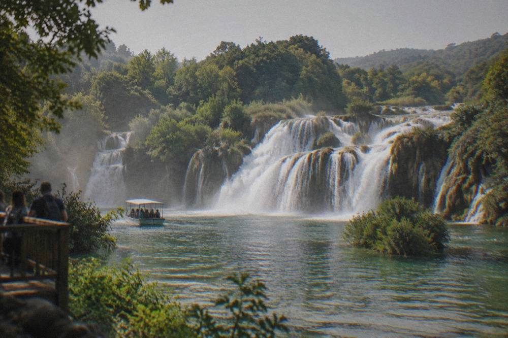 Wide waterfall cascading over travertine ledges into a green pool at Skradinski Buk