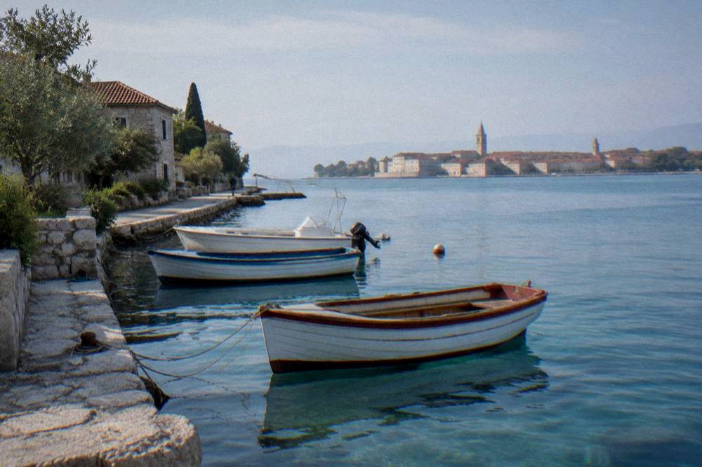 Boats tied at a stone quay in Arbanasi with calm water