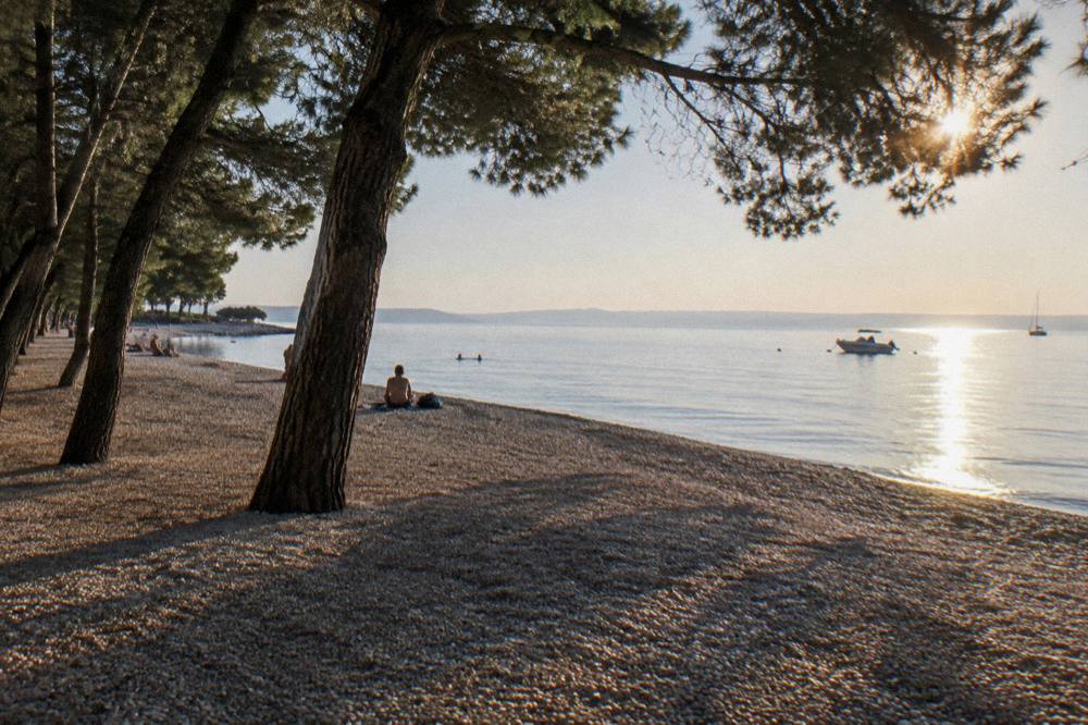 Late afternoon sun and pine shadows on Borik beach on a clear day
