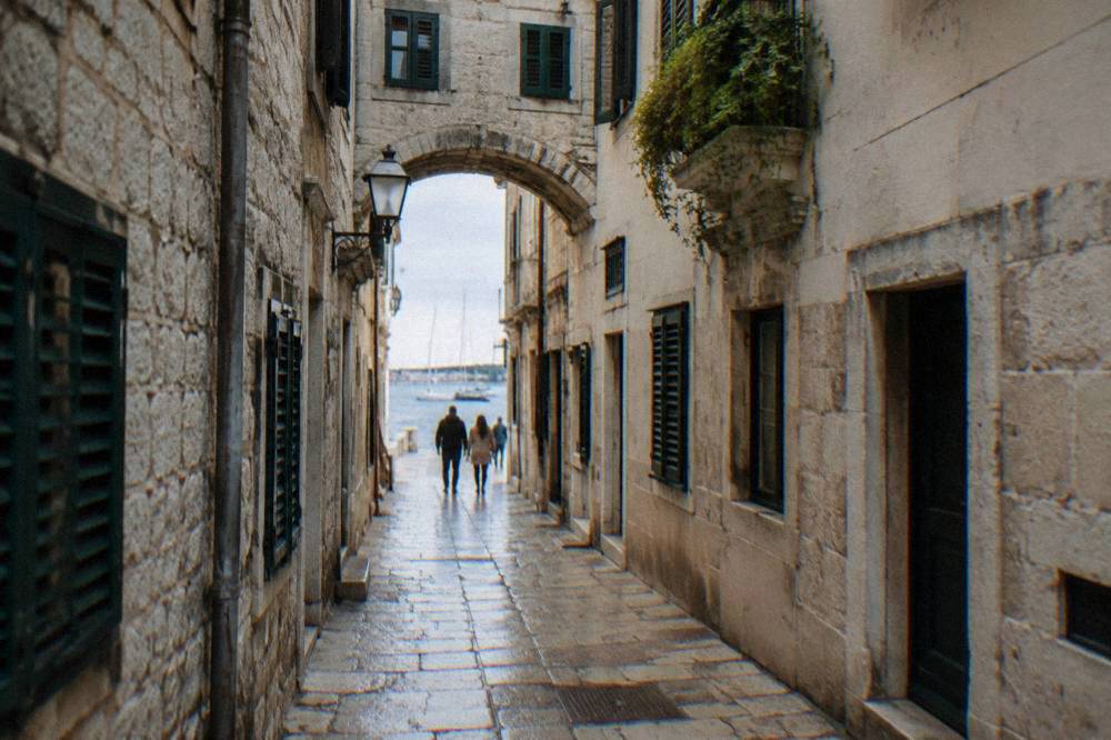 Narrow limestone lane with green shutters in the Zadar Old Town