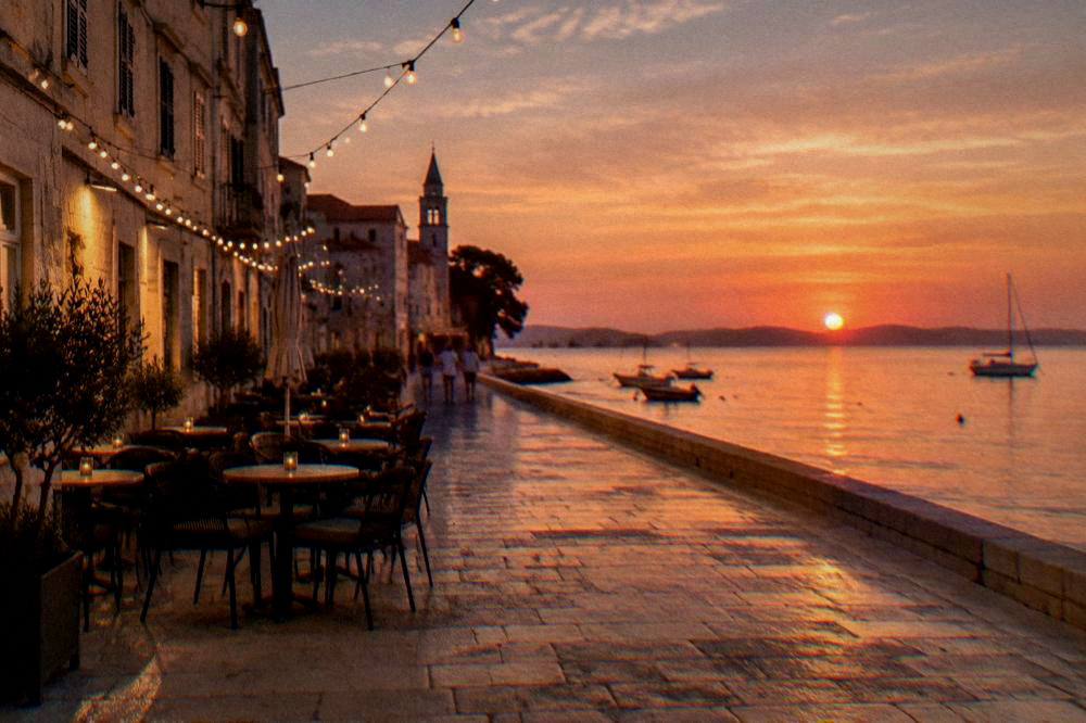 Old Town cafe tables on stone paving at dusk under string lights