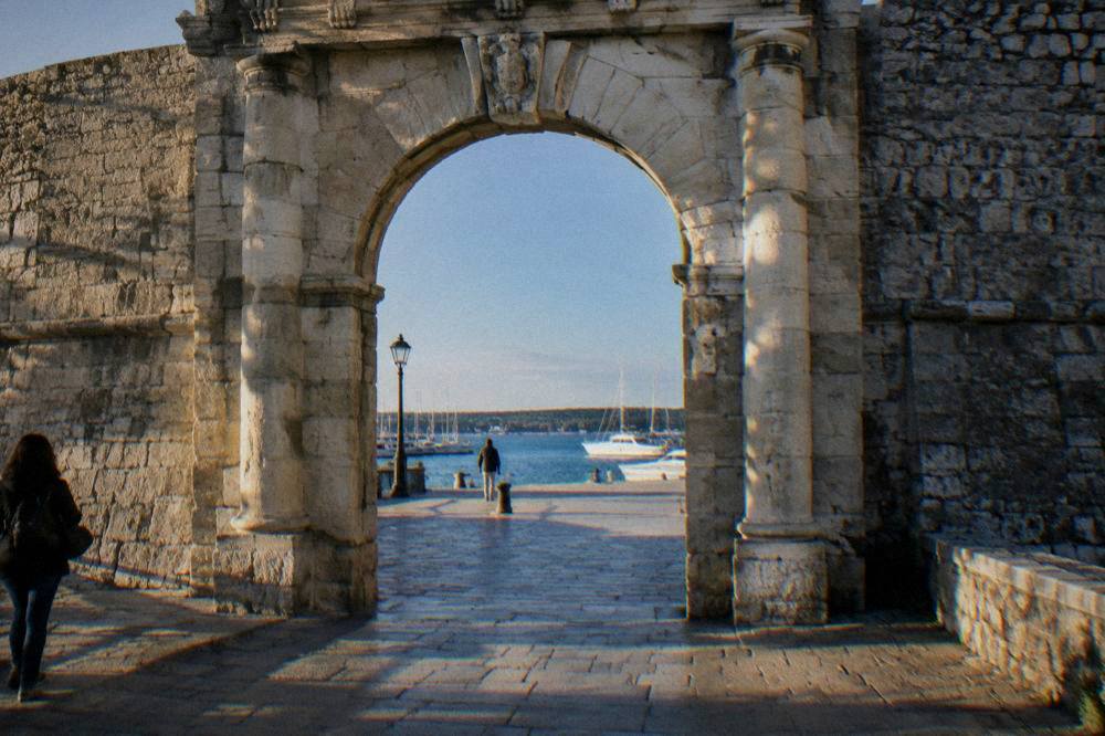 Stone gate arch opening onto the harbour in the Old Town walls