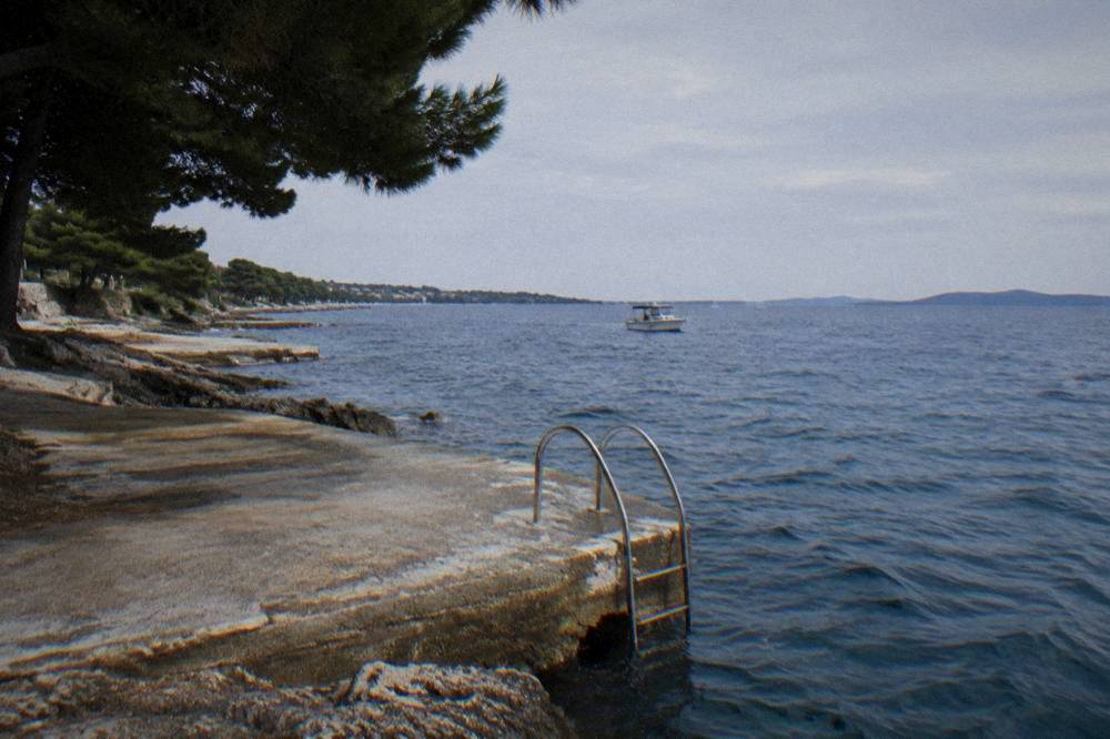 Sunbathing platform with a ladder into deep blue water at Puntamika