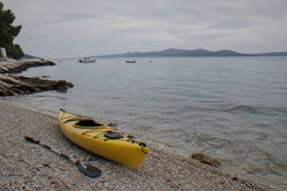 Kayak resting on pebbles at Puntamika with calm water beyond