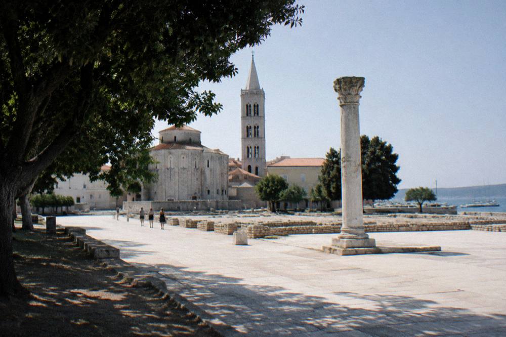 Roman forum paving and standing column beside the church bell tower