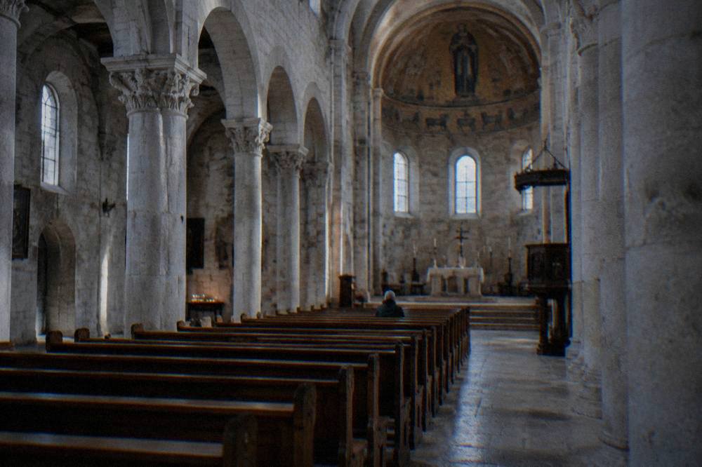 Stone columns and arches inside the cathedral with empty pews