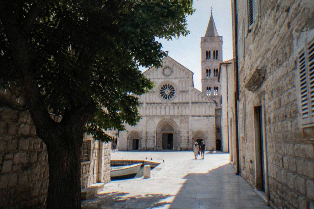 Old Town lane opening onto the cathedral facade in summer light