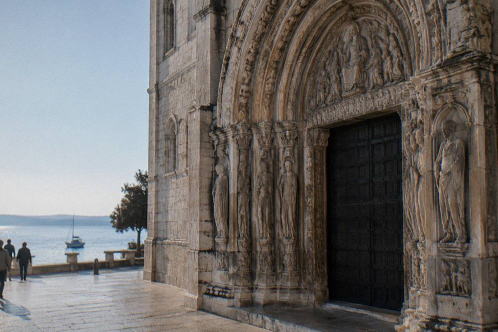 Weathered carved stone arch on the cathedral doorway in summer light