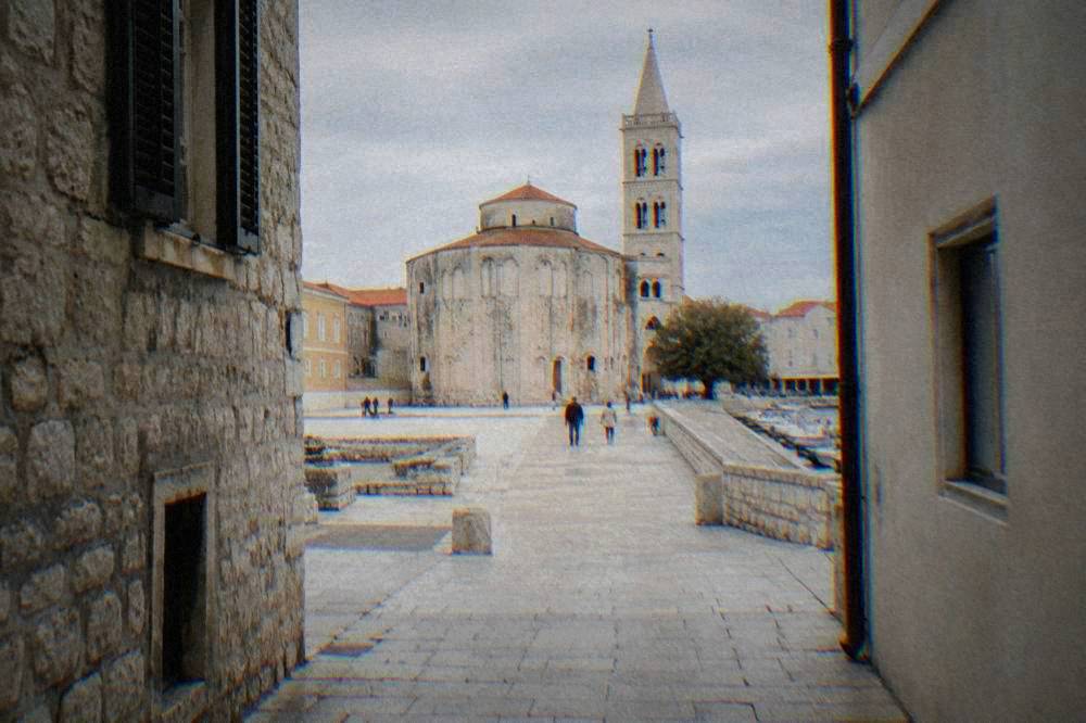Round church rising at the end of a narrow Old Town lane