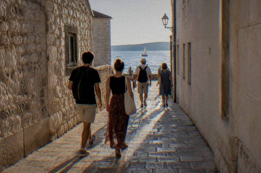 Walkers seen from behind strolling an Old Town stone lane
