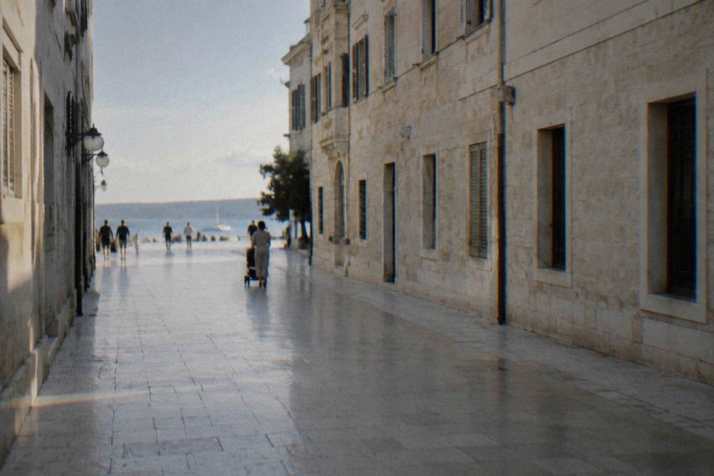 Smooth flat stone paving of the pedestrian street with a distant stroller