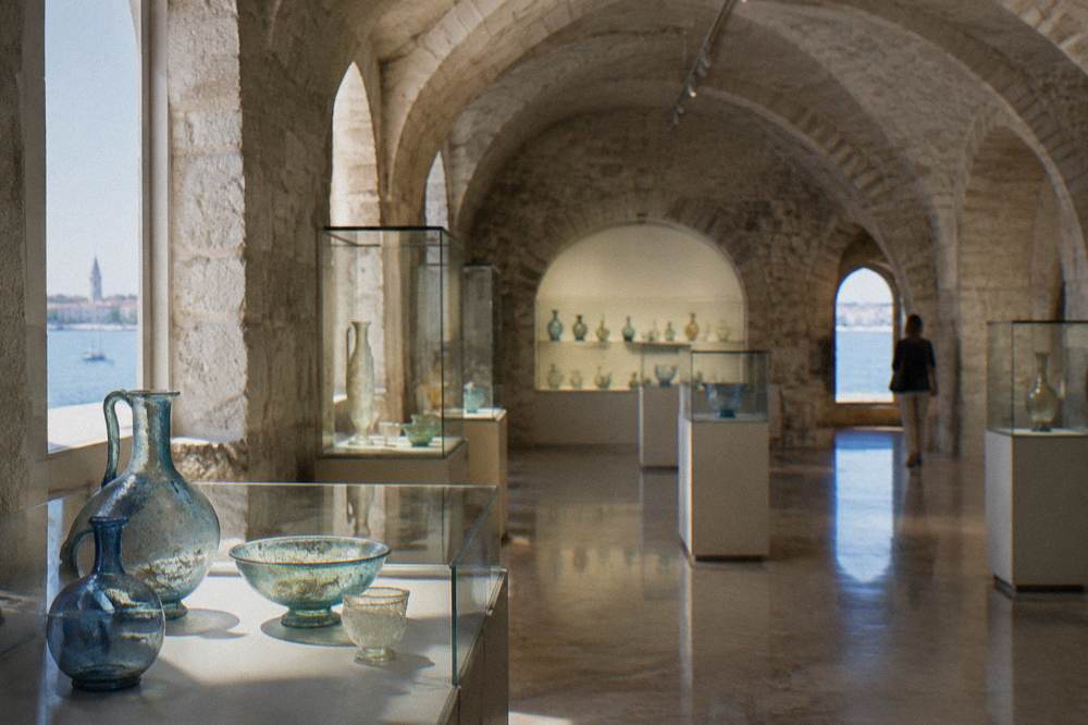 Quiet vaulted stone gallery with arched alcoves in summer light