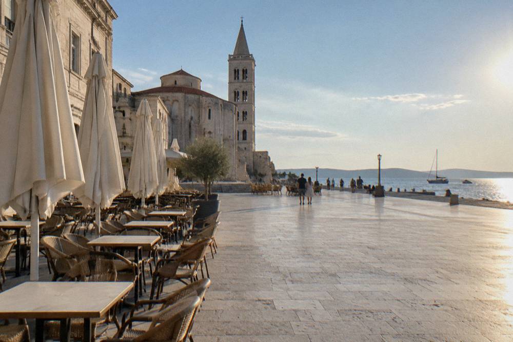 Cafe terraces with empty chairs and parasols along the square edge