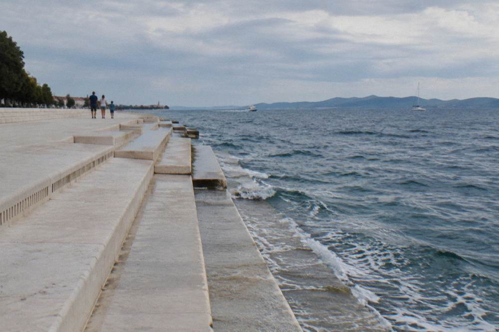 Open marble steps by the sea with a family sitting far away