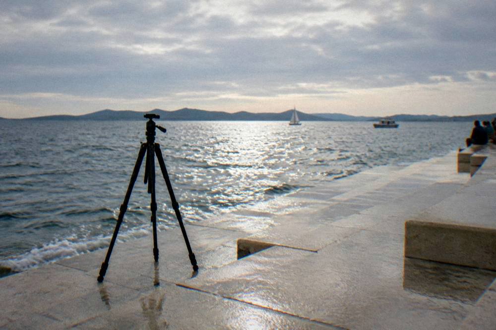 Low view over the water from the marble steps with a lone tripod