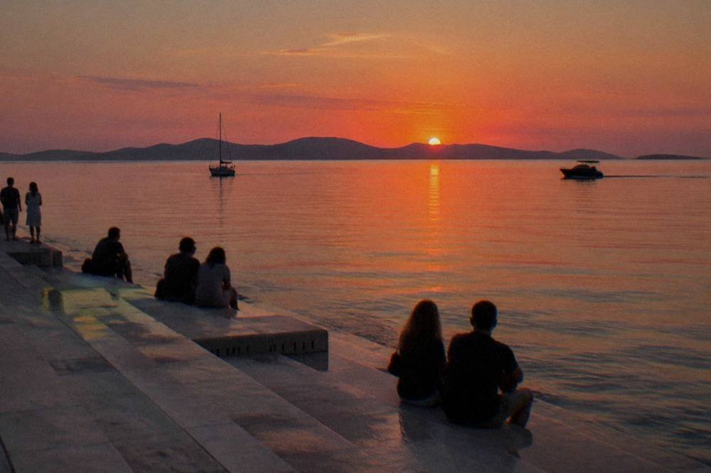 Sunset behind distant islands seen from the sea steps in soft natural light