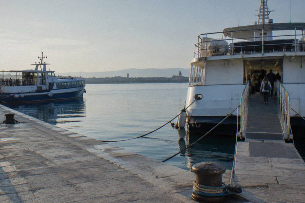 Excursion boats at a stone quay in calm morning light