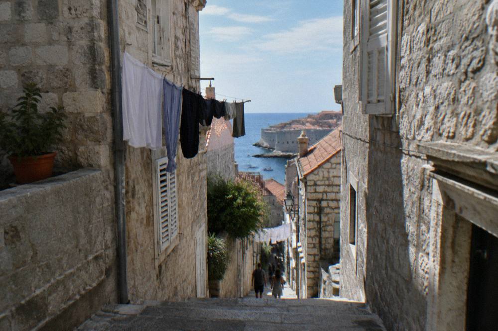 Stone steps climbing between pale houses in Dubrovnik in soft natural light