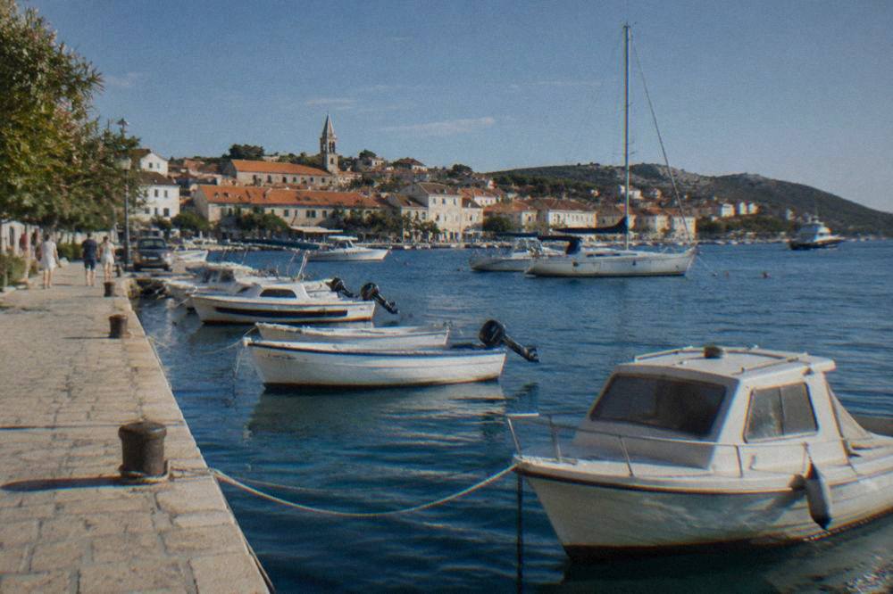 Murter waterfront with moored boats and terracotta houses in summer light