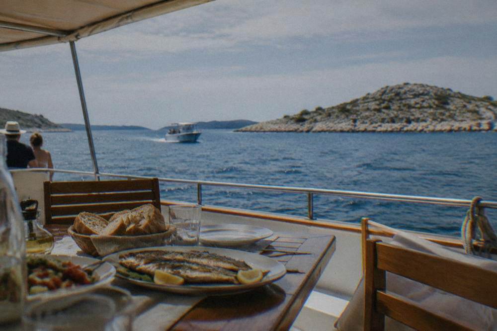 Boat deck lunch table under an awning with islands beyond