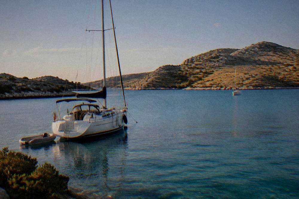 Late summer light on Kornati ridges with a moored sailing boat
