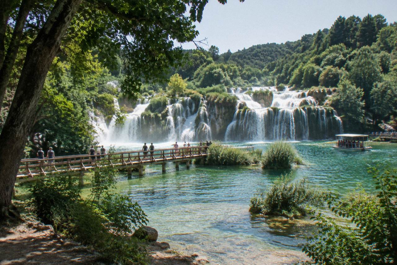 Skradinski Buk waterfalls over travertine terraces with wooden walkways on a clear day