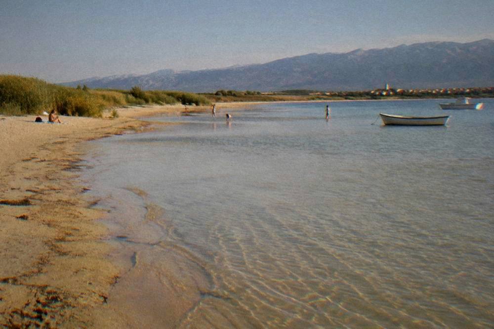 Wide shallow sandy beach near Nin with children playing far away