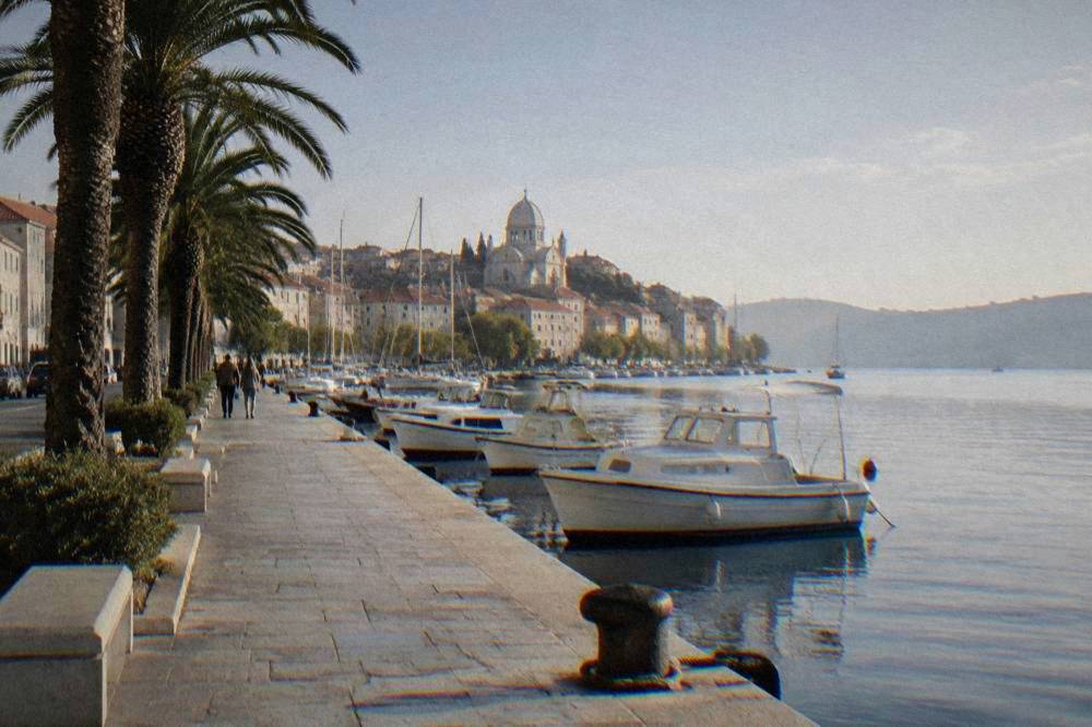 Sibenik waterfront with palms, moored boats and a stone quay
