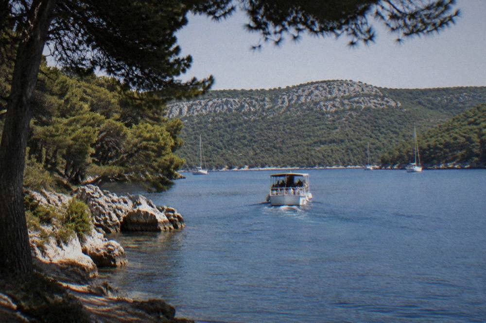 Excursion boat approaching the sheltered Telascica bay in soft natural light