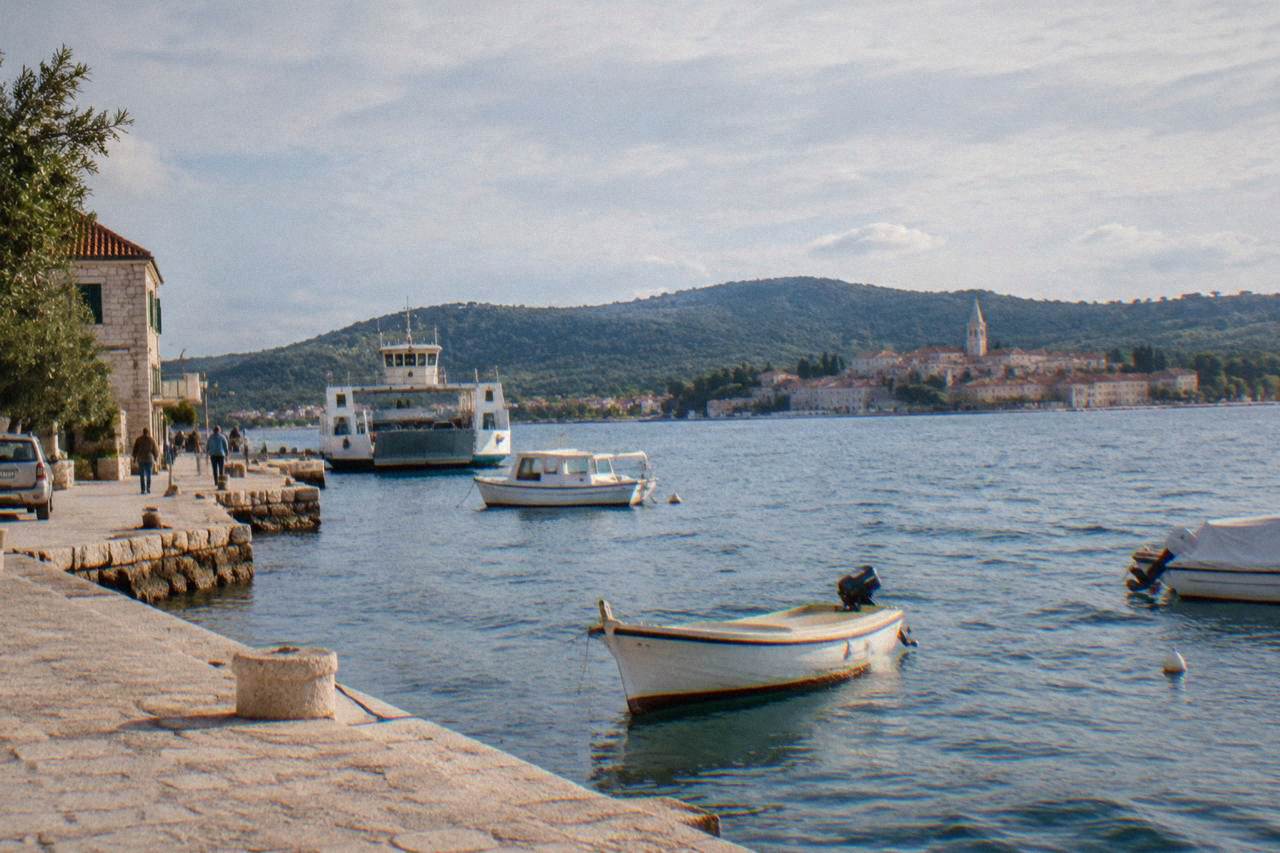 Preko harbour on Ugljan with a stone quay, boats and green hills