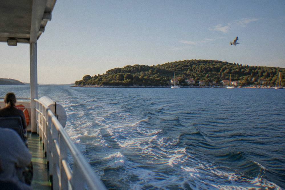 View from a boat deck toward Ugljan's wooded shore in summer light