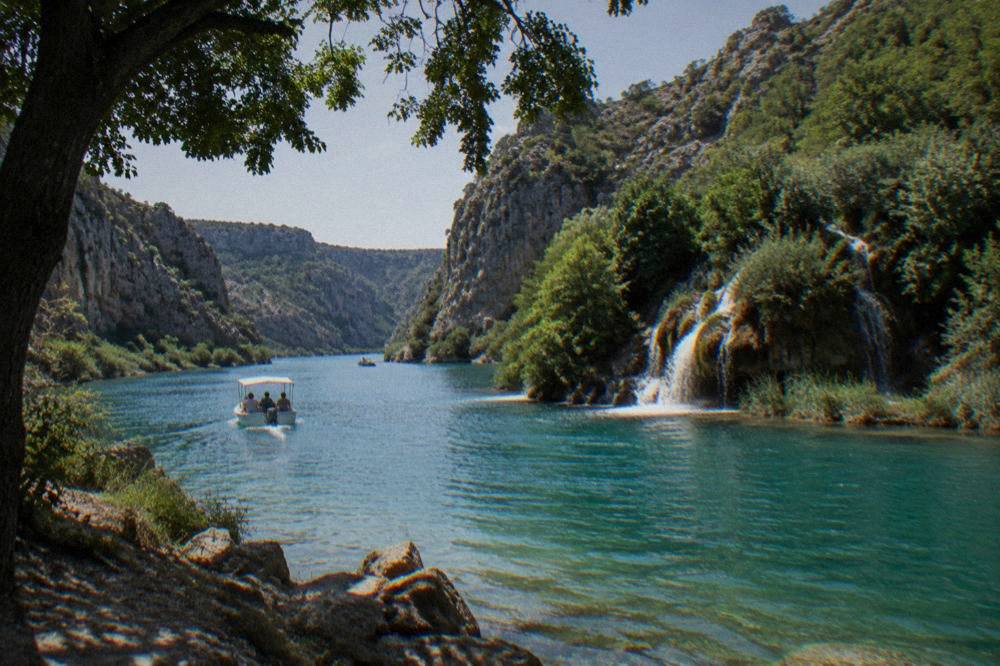 Turquoise Zrmanja river between steep limestone walls with small falls