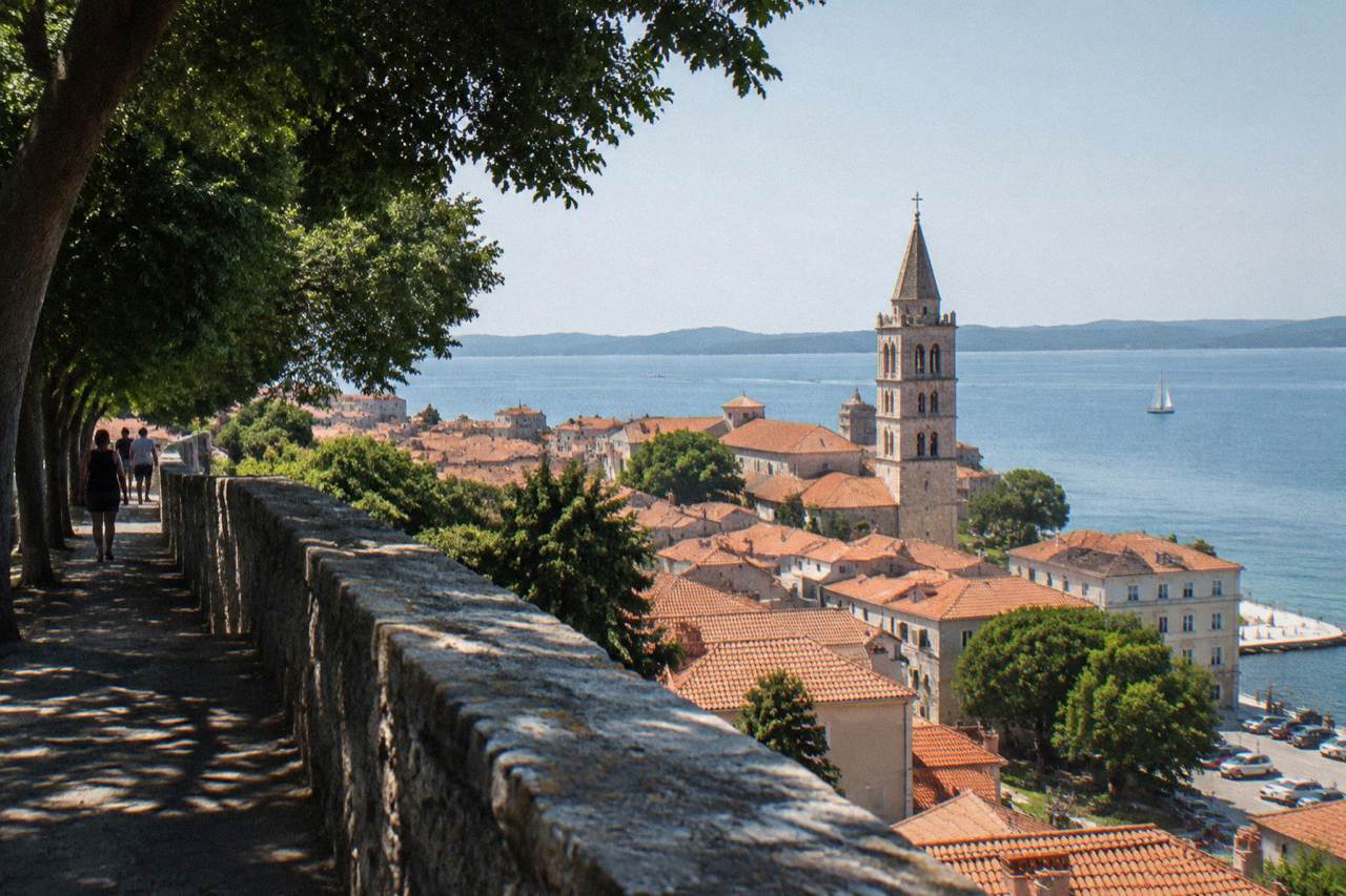 Terracotta rooftops of Zadar Old Town and the calm Adriatic seen from a high bastion wall.