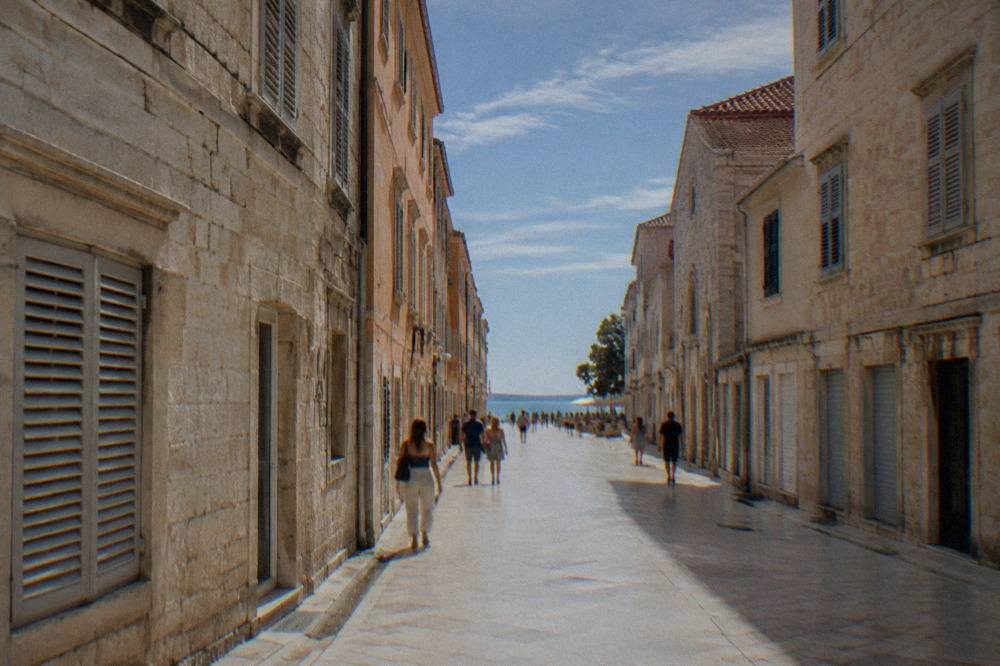 A sunlit summer afternoon on Zadar's main pedestrian street with distant strollers.