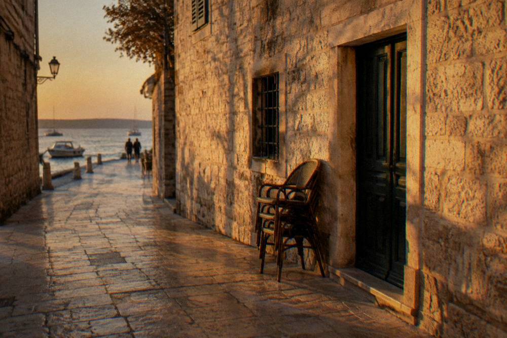 An empty limestone lane in Zadar Old Town glowing in warm autumn light.