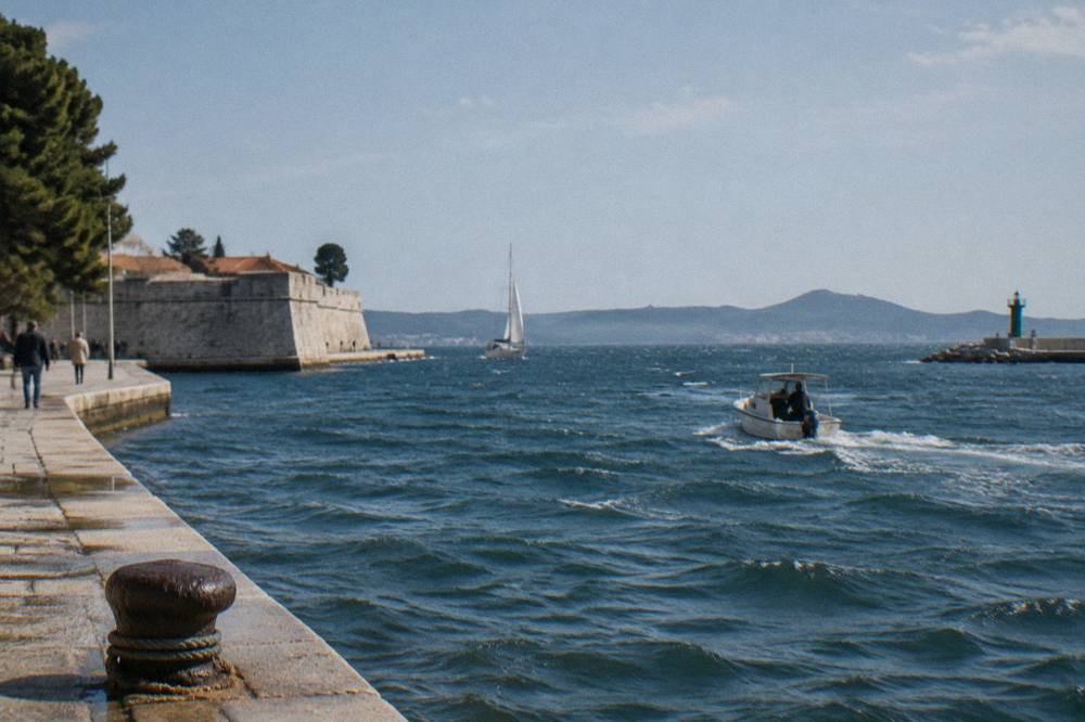 Small whitecaps on the blue Adriatic with a distant island coast on a breezy day.