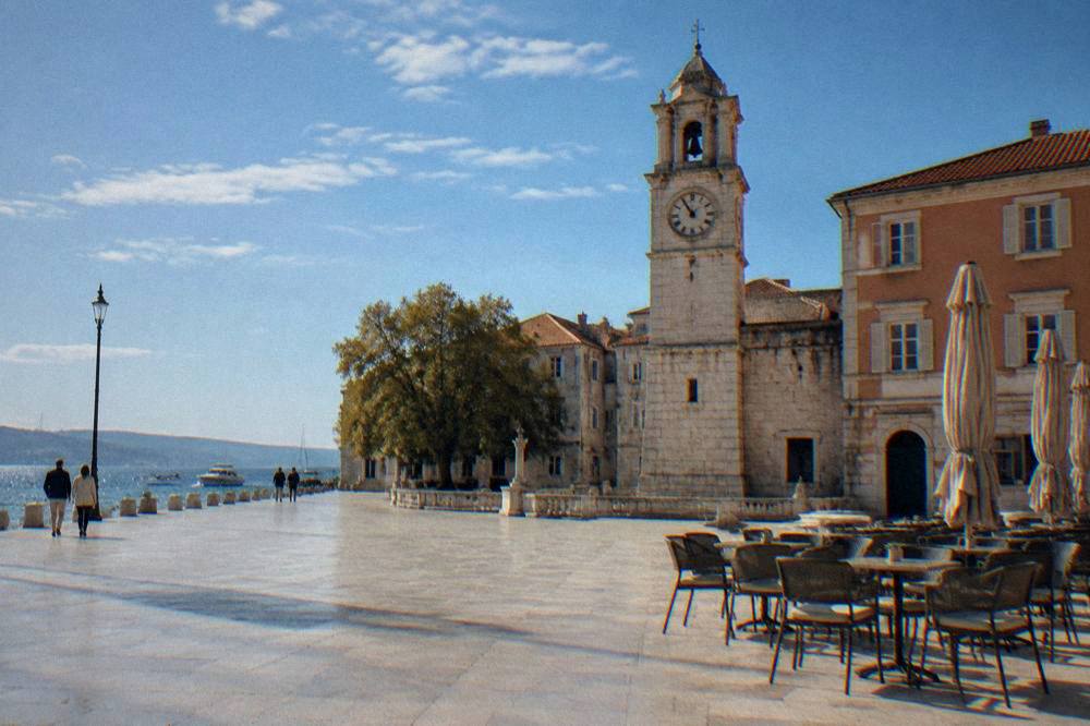 A quiet Old Town square in Zadar with pale paving and empty cafe chairs.